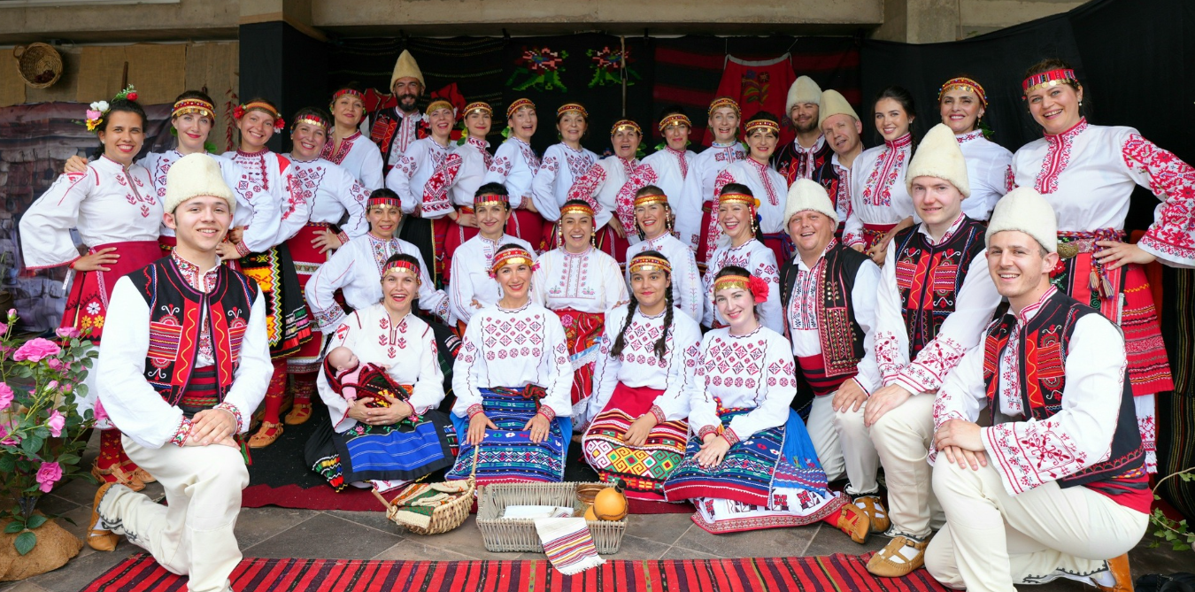 Zora dancers in traditional Bulgarian costume, smiling together